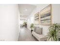 Bright hallway showcasing modern art, a bench, and access to living spaces at 3915 Wesvan Ct, Las Vegas, NV 89121