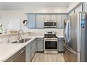 Well-lit kitchen with stainless steel appliances, gray cabinets, quartz countertops, and modern fixtures at 4014 Sparrow Rock St, Las Vegas, NV 89129