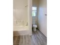 Bright bathroom featuring a shower-tub combination and a toilet next to a window at 4356 Pittsfield St, Las Vegas, NV 89115