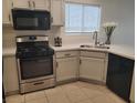 Bright kitchen features white cabinets, stainless steel appliances, and tiled floor at 4356 Pittsfield St, Las Vegas, NV 89115