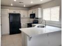Spacious kitchen with quartz countertops, tiled floors, stainless steel appliances, and white cabinets at 4356 Pittsfield St, Las Vegas, NV 89115