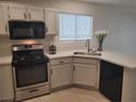 This bright kitchen features white cabinets, stainless steel appliances, and tiled floors at 4356 Pittsfield St, Las Vegas, NV 89115