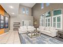 An open-concept living room with high ceilings, bright white sofas, and a stylish rug at 4573 Milvio Ave, Las Vegas, NV 89141