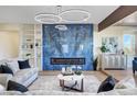 Open concept living room with a blue tile accent wall and fireplace at 4574 Fiore Bella Blvd, Las Vegas, NV 89135
