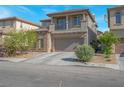 Two-story home featuring a balcony, neutral stucco, stone accents, finished two-car garage and manicured landscaping at 4992 W Moberly Ave, Las Vegas, NV 89139