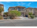 Two-story home featuring a balcony, neutral stucco, stone accents, finished two-car garage and manicured landscaping at 4992 W Moberly Ave, Las Vegas, NV 89139