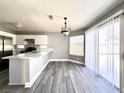 Open-concept kitchen showcasing stainless steel appliances, an island bar, and sliding door access at 5720 Ruby Creek Dr, Las Vegas, NV 89142