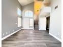 Inviting living room with high ceilings, large windows, and a staircase leading to the second floor at 5720 Ruby Creek Dr, Las Vegas, NV 89142
