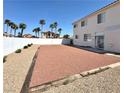 Spacious backyard with a patio area, surrounded by wood and a white fence at 66 John Stuart Mill St, Henderson, NV 89002