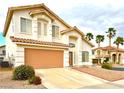 Charming two-story home featuring a tile roof, manicured landscaping, and an attached two-car garage at 66 John Stuart Mill St, Henderson, NV 89002