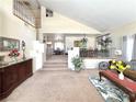 Bright living room with high ceilings, an open staircase, and views into the dining area at 66 John Stuart Mill St, Henderson, NV 89002