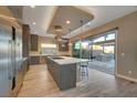 Modern kitchen with stainless steel appliances, a large island, and sliding doors to the outdoor patio at 6832 Apogee Ridge Ct, Las Vegas, NV 89135