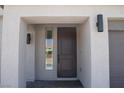 Close up of a modern front door with sidelight and contemporary exterior lighting at 6837 Crimson Lily St, Las Vegas, NV 89139