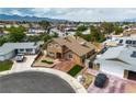 An aerial view of a home with well-kept lawn and driveway, set against a suburban landscape at 7604 Charles Conrad Cir, Las Vegas, NV 89145
