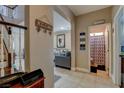 Hallway featuring tile floors and staircase view with view into the living room and an adjacent powder room at 8022 Severn Valley St, Las Vegas, NV 89139