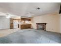 Spacious living room featuring carpeted floors, a cozy brick fireplace, and an open layout at 804 S Mallard St, Las Vegas, NV 89107