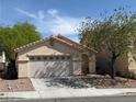 Well-maintained single-story home with a two-car garage, desert landscaping, and a mature tree at 8616 Hidden Pines Ave, Las Vegas, NV 89143