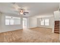 Spacious carpeted living room with a ceiling fan and natural light from a large window at 8626 Anderson Dale Ave, Las Vegas, NV 89178