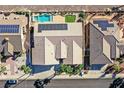 An aerial view showcases the home's layout and the inviting pool with solar panels amidst desert landscaping at 904 Rhyolite Ter, Henderson, NV 89011