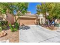 Charming home with a two-car garage, desert landscaping, and a concrete driveway at 9773 Bedstraw St, Las Vegas, NV 89178