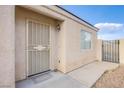 Close up of front door with security screen, tan stucco, small window, and gravel landscaping at , Las Vegas, NV 89130