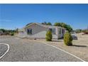 Charming single-story house surrounded by a gravel driveway and desert landscaping at 1450 Fern St, Pahrump, NV 89060