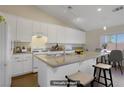 Bright kitchen featuring white cabinets, granite countertops, and an island with seating at 1766 Baja Ln, Henderson, NV 89012