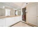 Elegant bathroom featuring dual sinks, marble countertops, and a glass-enclosed shower at 2877 Paradise Rd # 1806, Las Vegas, NV 89109