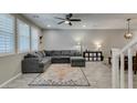 Spacious living room featuring tile floors, modern ceiling fan, and natural light from large windows at 3166 Via Da Vinci, Henderson, NV 89044