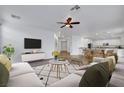 Bright, open-concept living space offers modern decor, lots of natural light, and flows into the kitchen and dining area at 3217 Palladio Ave, North Las Vegas, NV 89031
