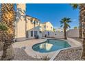 A private backyard featuring a kidney-shaped swimming pool surrounded by desert landscaping and mature palm trees at 3525 Tuscany Village Dr, Las Vegas, NV 89129