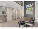 Bright dining room with modern table, chairs, staircase, and whimsical art at 36 Lakefront Dr, Henderson, NV 89011