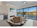 Bright living room with fireplace, wet bar, and expansive windows showcasing beautiful outdoor views at 36 Lakefront Dr, Henderson, NV 89011