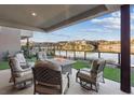Beautiful outdoor patio with a fire pit and comfortable seating overlooking a serene lake at 36 Lakefront Dr, Henderson, NV 89011