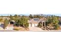 Spacious single-story home with a tile roof, solar panels, desert landscaping, and a three-car garage at 5193 N Miller Ln, Las Vegas, NV 89149
