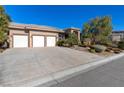 Single-story home with a tile roof, three-car garage, desert landscaping, and a spacious driveway at 5193 N Miller Ln, Las Vegas, NV 89149