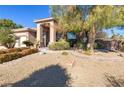 Desert landscaping highlights the stone accents and covered entry of this single-story home at 5193 N Miller Ln, Las Vegas, NV 89149
