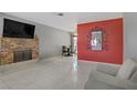 Bright living room with a brick fireplace, TV and neutral tile flooring at 5463 Waltham Ln, Las Vegas, NV 89122