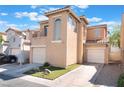 This townhome features a two-story layout, personal garage, driveway, balcony, and tidy desert landscaping at 6270 Dartington Hall St, Henderson, NV 89011