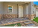 Covered front porch entry features stone brick flooring and supporting pillars; perfect for enjoying a cool drink on a summer day at 759 Praire Plume St, Henderson, NV 89011
