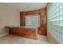 Entertaining bar area with custom cabinetry, a unique glass block window, and ample counter space at 7969 Bermuda Dunes Ave, Las Vegas, NV 89113