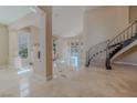 Spacious living room featuring a staircase, tile floors, and light-filled windows at 7969 Bermuda Dunes Ave, Las Vegas, NV 89113
