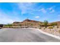 Scenic community landscape with a prominent mountain backdrop, showcasing desert landscaping and clear blue skies at 9565 Camelback Creek Dr, Las Vegas, NV 89178