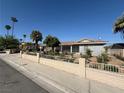 Lovely single-story home with a light-colored exterior, decorative front fence, and attractive landscaping at , Las Vegas, NV 89121