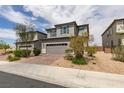 Charming two-story home featuring a gray color scheme, complemented by a well-manicured lawn and a two-car garage at 1004 Huckburn Ave, Henderson, NV 89015