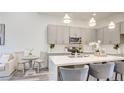 Bright kitchen featuring stainless appliances, quartz countertops, a breakfast bar, and open floorplan living at 1157 Blossom Point St, Las Vegas, NV 89135