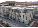 Modern townhome complex featuring multiple units with neutral toned exterior and mountain views in the background at 1163 Blossom Point St, Las Vegas, NV 89135