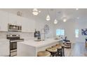 Bright, modern kitchen with stainless steel appliances, white cabinets, pendant lighting, and a quartz countertop island at 1181 Blossom Point St, Las Vegas, NV 89135