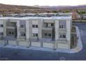 Modern townhome exterior with multiple balconies, gray stone accents, and a two-car garage at 1187 Blossom Point St # 36, Las Vegas, NV 89135