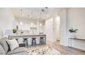 Bright open floor plan with modern lighting, kitchen island, and stylish gray sofa at 1187 Blossom Point St # 36, Las Vegas, NV 89135